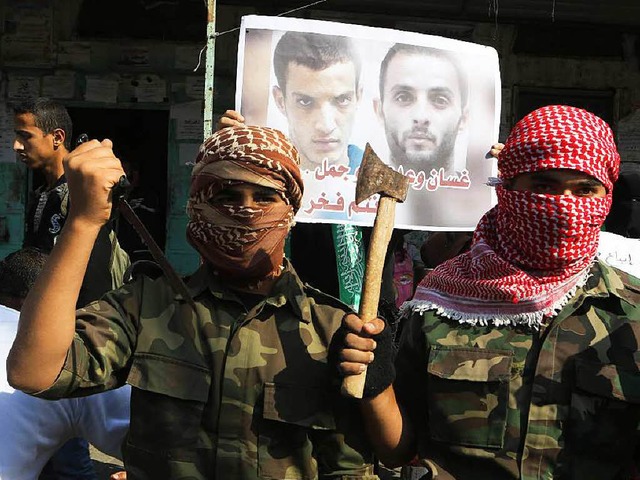 Messer, Axt, Pistole &#8211; demonstra...en.  Im Hintergrund Bilder der Tter.   | Foto: AFP
