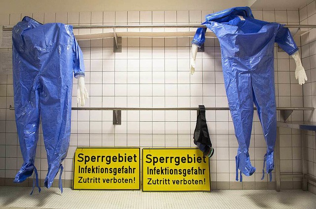 Schutzanzge hngen im Ankleideraum ei...openkrankheiten wie Ebola aufzunehmen.  | Foto: dpa