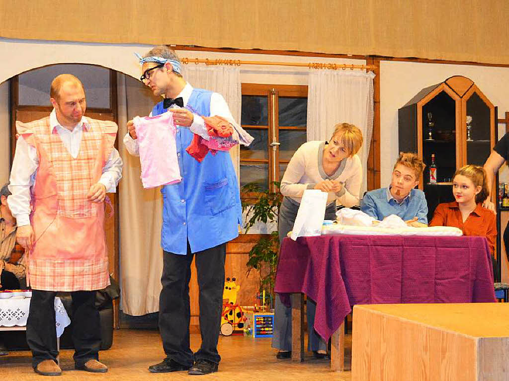 Theaterabend des Musikvereins Biederbach: Die eigenen Frauen aus dem Haus und die beiden Ehemnner „schmeien“ den Haushalt –  mehr schlecht als recht.