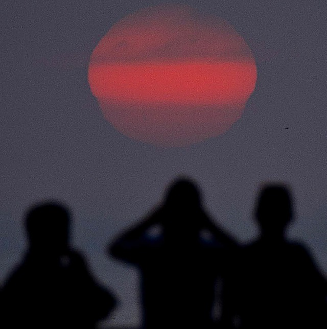 Tagungsteilnehmer schauen in Limas Sonnenuntergang.   | Foto: AFP