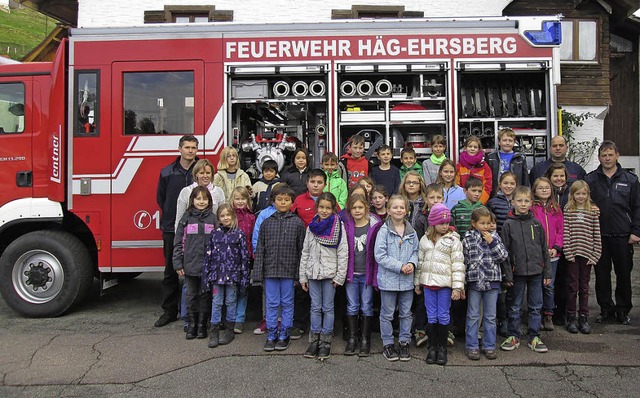 Schlerinnen, Schler und Lehrer der A...euerwehrmnnern vor dem Lschfahrzeug   | Foto: Karl-Heinz Rmmele