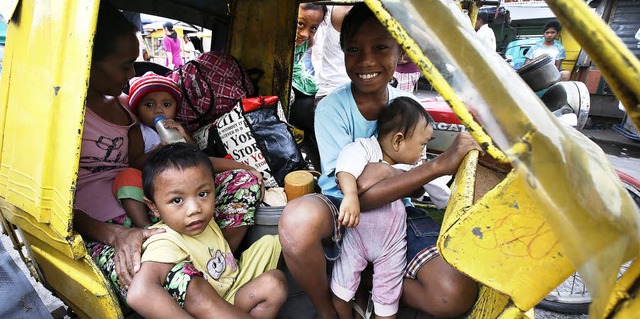 Eine mittellose Familie fhrt in Manil...r Philippinen, in eine Notunterkunft.   | Foto: DPA