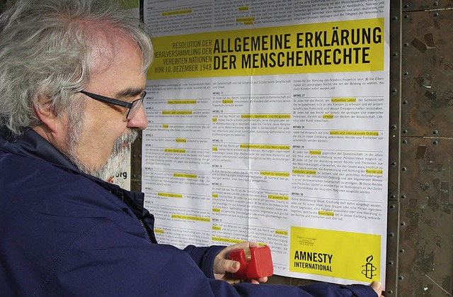 Pfarrer Hellmuth Wolff hngt das Plakat auf.  | Foto: Joachim Frommherz