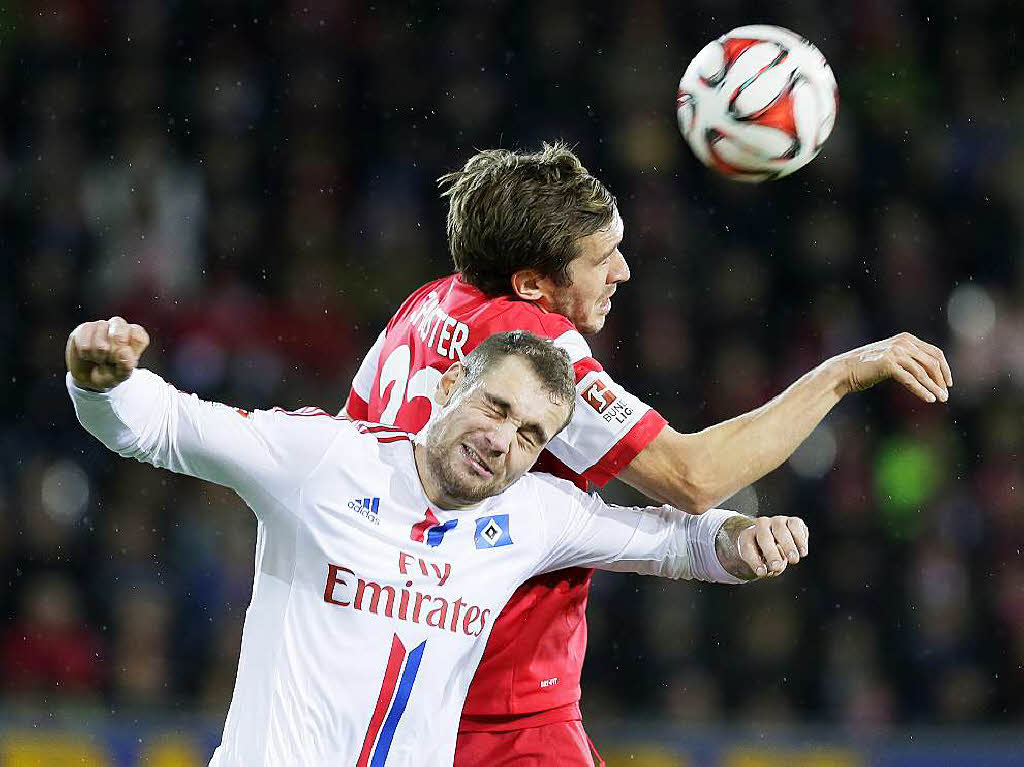 Freiburgs Julian Schuster (r) kmpft um den Ball mit Pierre-Michel Lasogga von Hamburg.