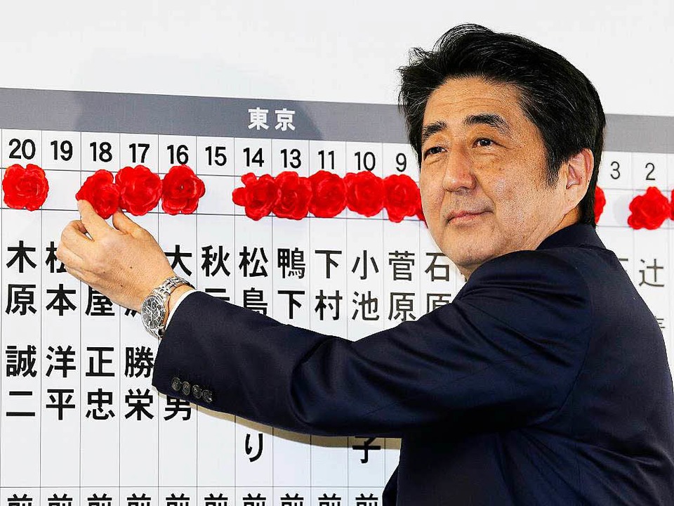 Shinzo Abe markiert mit Rosen die Name... Kandidaten, die bei der Wahl siegten.  | Foto: dpa