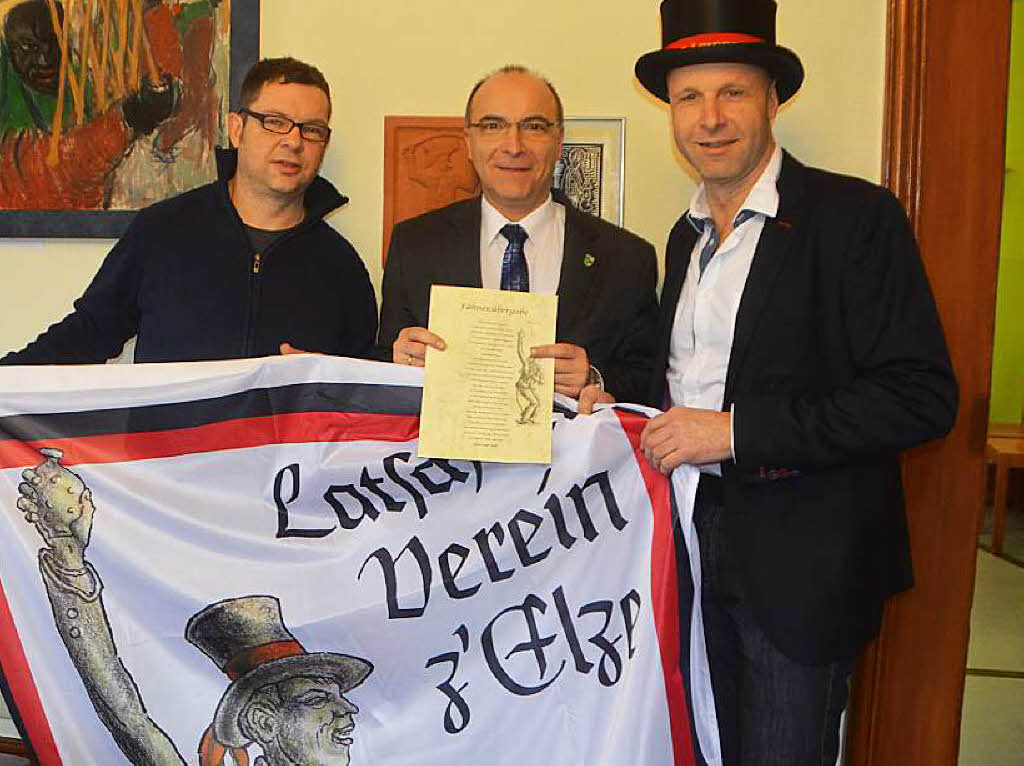 Jetz guck do,  ein Prsent vom Prsident: Hans-Peter Riegger (rechts) und Alexander Ketterer (links) berbrachten Brgermeister Roland Tibi eine groe Latscharifahne frs Rathaus.