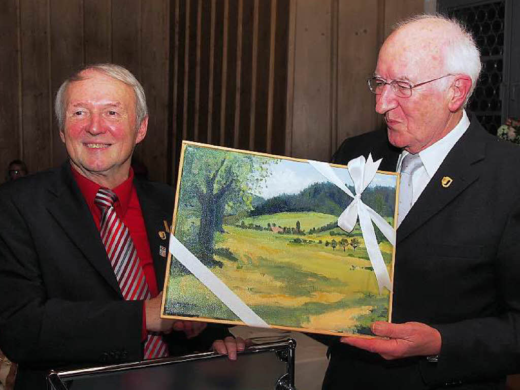 Walter Rombach (rechts) berreicht ein Bild des Malers Roland Jenne mit dem Giersberg an Franz Kromer