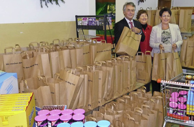 Volksbank-Direktor Erhard Stoll und se...g (Mitte) mit 150 Waren-Geschenktten.  | Foto: Manfred Burkert