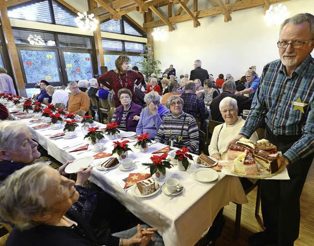 Der ehrenamtliche Helfer Emil Pfistner (rechts) teilt Kaffee und Kuchen aus.   | Foto: ingo schneider