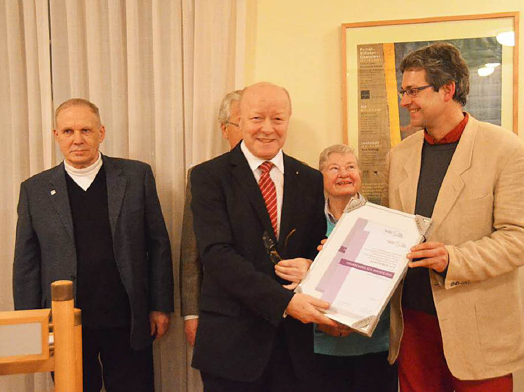 Norbert Dietrich, Vorsitzender der Brgerstiftung,  gibt die Urkunde an Jrg Hinderer (rechts) und Herweg Popken, beide Freundeskreis Asyl