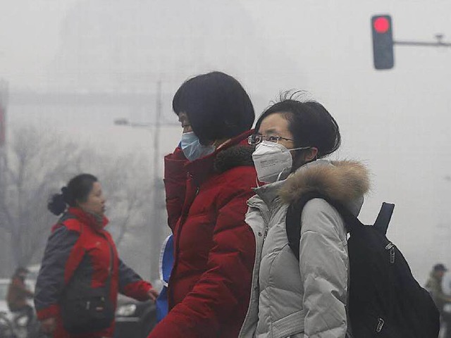 Alltag in Peking: mit Atemschutzmaske auf der Strae  | Foto: dpa
