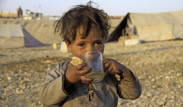 Ein Mdchen trinkt Tee in einem Flchtlingslager in Afghanistan.   | Foto: DPA