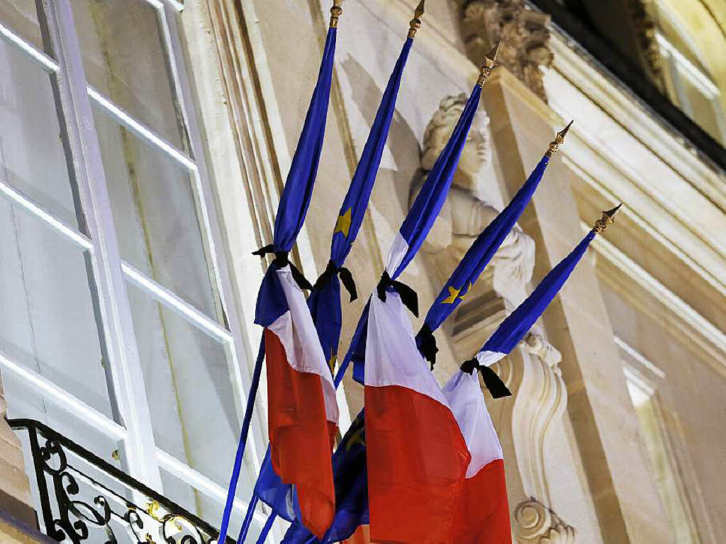 Die Flaggen am Elysee-Palast in Paris werden von schwarzem Trauerflor zusammengehalten.