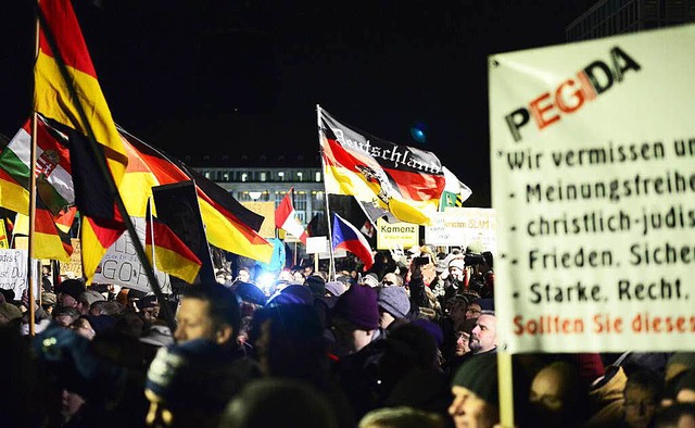 Deutschland-Fahnen mit und ohne Trauerflor: Pegida in Dresden.  | Foto: AFP
