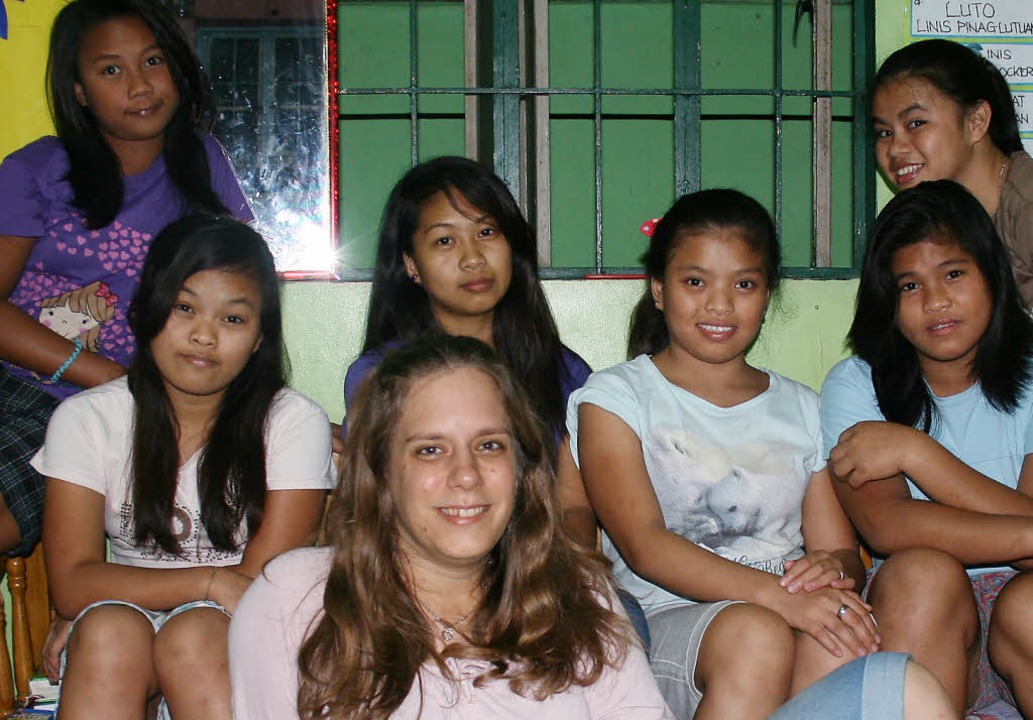 Daniela Rühle (vorne Mitte) mit ihren ...lingen im Wohnhaus im Slum von Manila   | Foto: PRIVAT