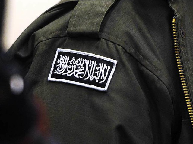 Ein Prozessbeobachter trgt das islami...ekenntnis auf seiner schwarzen Jacke.   | Foto: DPA