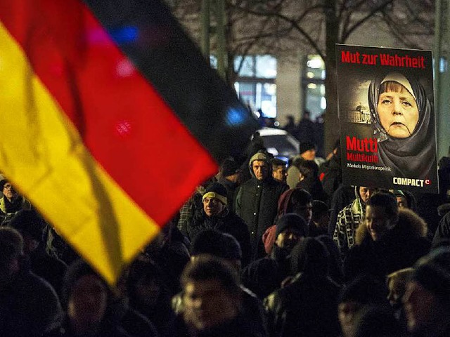 Deutschland-Fahnen und Merkel im Kopftuch: Die Ikonografie von Legida.  | Foto: AFP