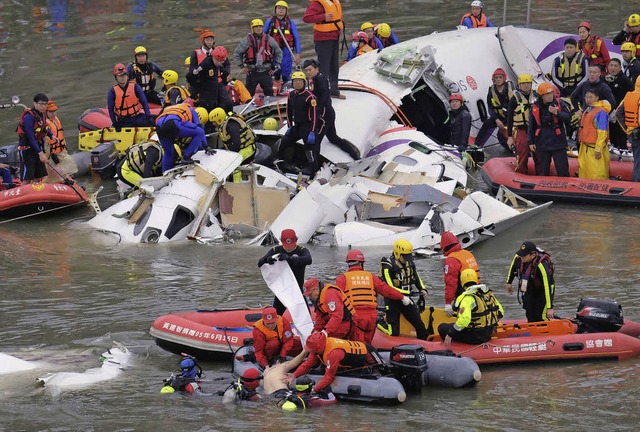 Retter bergen einen berlebenden aus dem Flugzeugwrack.   | Foto: dpa