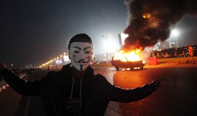 Ein Fan des gyptischen Fuballclubs Z... Hintergrund brennt ein Polizeiauto.    | Foto: dpa