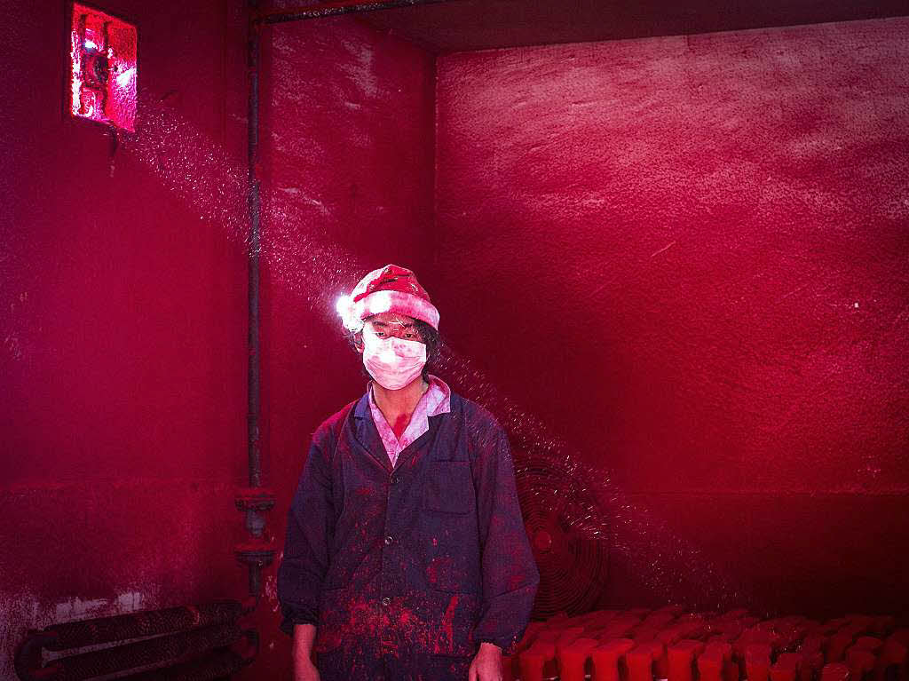„Christmas Factory“  heit das Bild mit dem der chinesische Fotograf Ronghui Chen den 2. Preis in der Kategorie „Aktuelle Themen“ gewinnt. Die rote Weihnachtsmtze dient als Schutz vor giftigen Dmpfen.