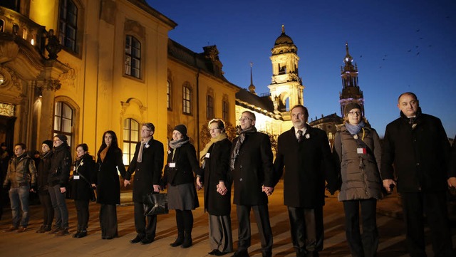 Die  Dresdener reichen sich zum Gedenk...die  Zerstrung der Stadt  die Hnde.   | Foto: DPA