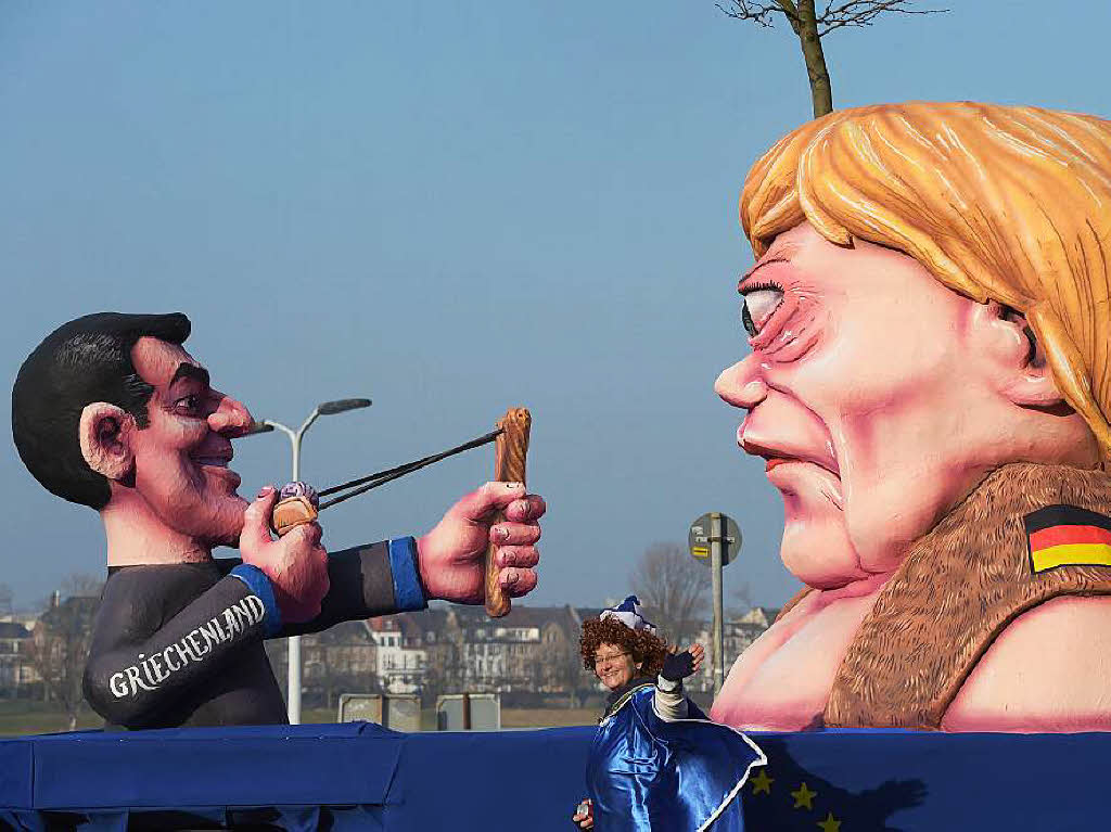 Athen vs. Berlin: Auf dem Karnevalswagen in Dsseldorf zielt der griechische Ministerprsident Alexis Tsirpas mit einer Steinschleuder auf Bundeskanzlerin Angela Merkel.