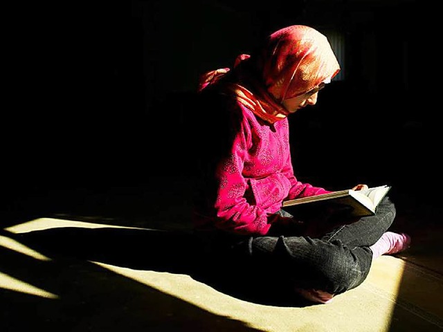 Eine Muslima bei der Koran-Lektre   | Foto: dpa/Ossenberg