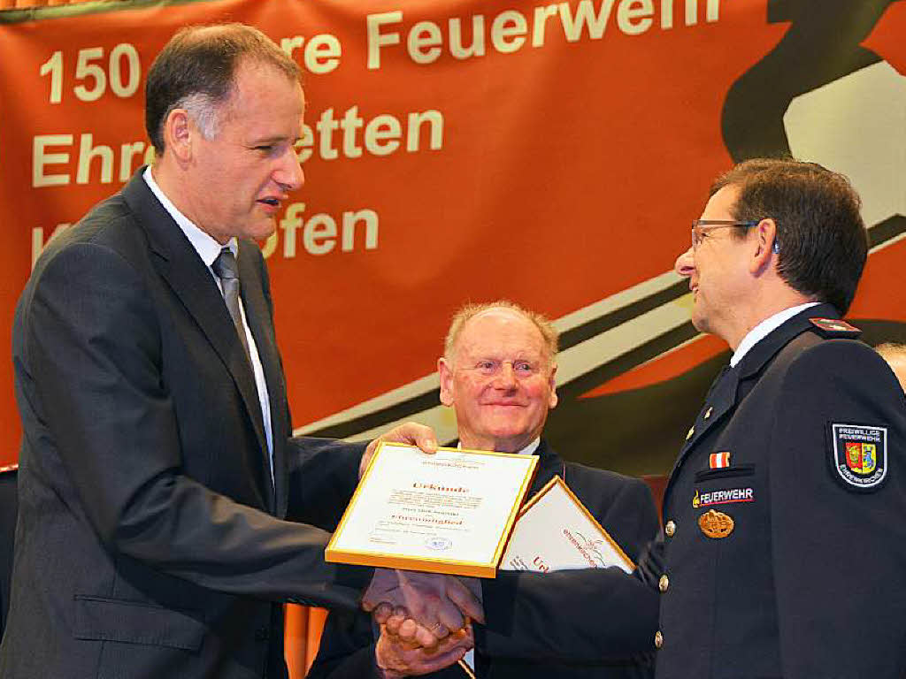 Thomas Breig gratuliert Dirk Sawitzki, neues Ehrenmitglied der Feuerwehr Ehrenkirchen, im Hintergrund Willi Nageleisen.