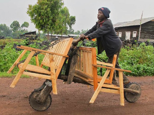 David Bisore transportiert zwei Bnke ... Kongo beliebten  Chikudu-Tretrollern.  | Foto: Dieterich 