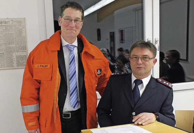 Kommandant Hilmar Singler (rechts) hat...ine Einsatzjacke mit Helm berreicht.   | Foto: Rudi Rest