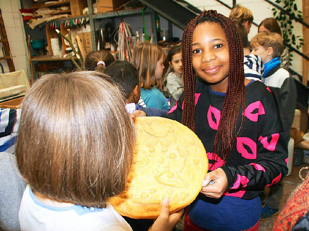 Juliet Okpara in der Werkstatt mit einer Pizza 