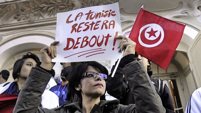 &#8222;Tunesien wird sich nicht beugen...child, das die Frau in die Hhe hlt.   | Foto: AFP