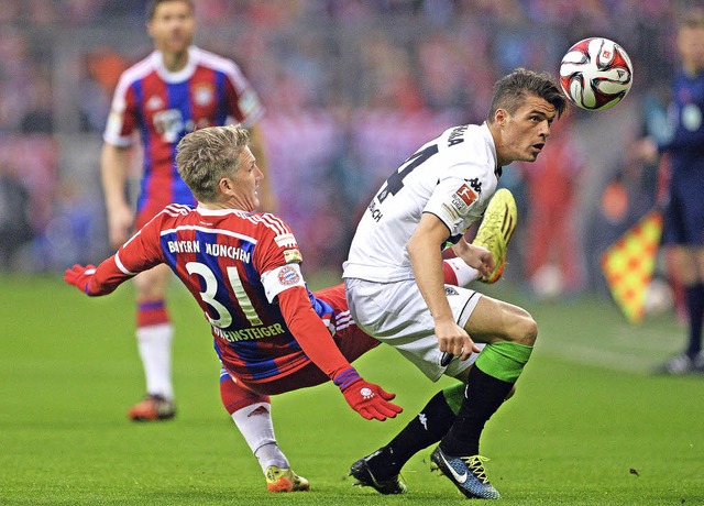 Bastian Schweinsteiger (links) kommt i... Granit Xhaka nicht mehr an den Ball.   | Foto: DPA