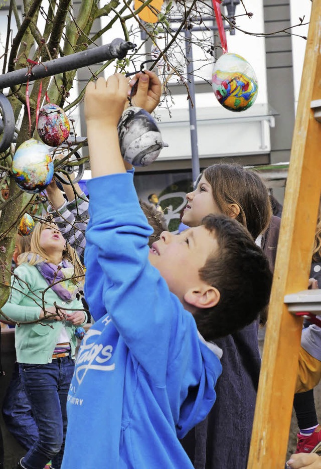 Der OB hat mit Schlern den Osterstrauch am Emmendinger Marktplatz geschmckt  | Foto: Julian Burmeister