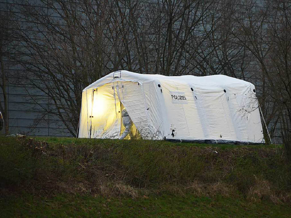 Auf dem Kinzigdamm, neben der Baden-Arena, steht das Zelt, in dem  Kriminalisten den Fundort der Leiche nach Spuren untersuchen.