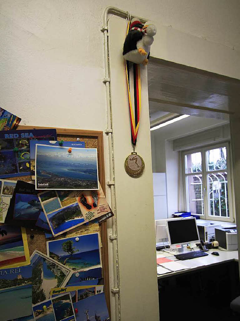 An der Wand hngen Urlaubspostkarten und eine Medaille von einem Schwimmwettbewerb.