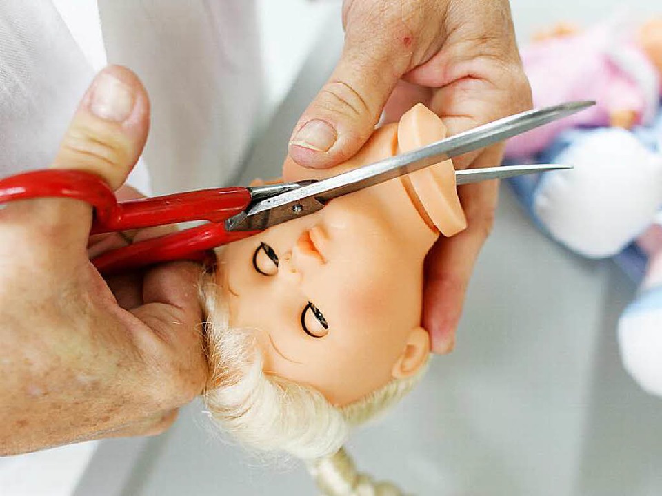 Ein TÜV-Mitarbeiter zerschneidet vor der chemischen Analyse eine Puppe  | Foto: usage worldwide, Verwendung weltweit