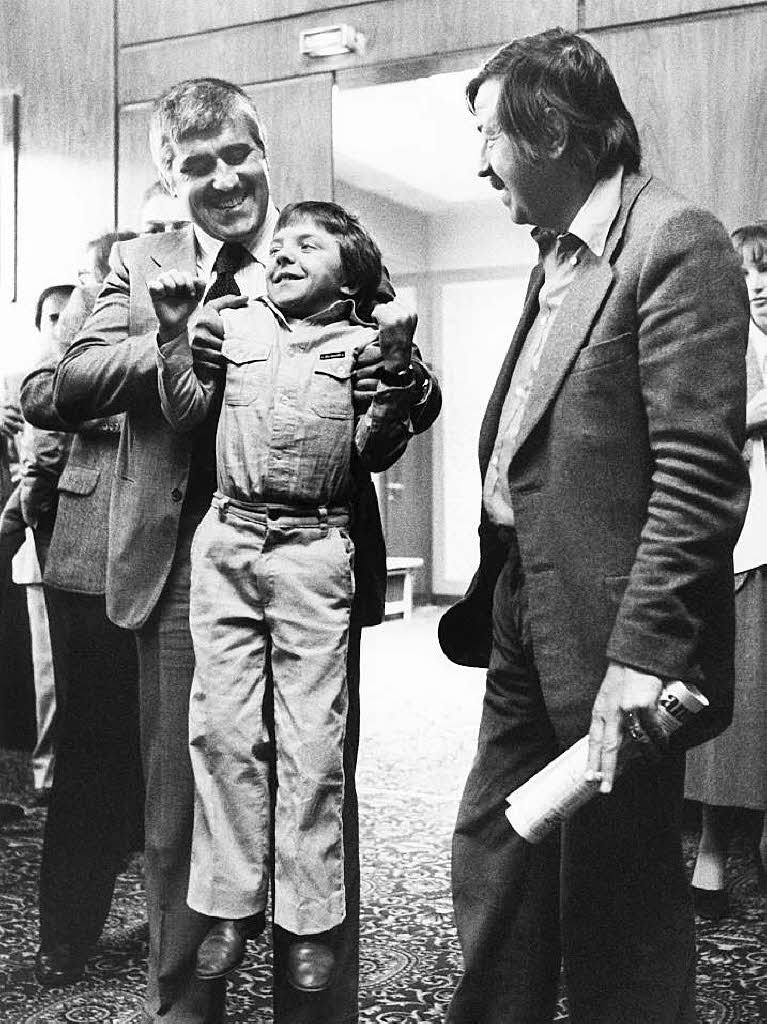 David Bennent, der 12-jhrige Hauptdarsteller, wird auf der Pressekonferenz vor der Urauffhrung des Films "Die Blechtrommel" am 03.05.1979 in Berlin von seinem Filmvater Mario Adorf hochgehoben. Rechts der Autor der Romanvorlage,