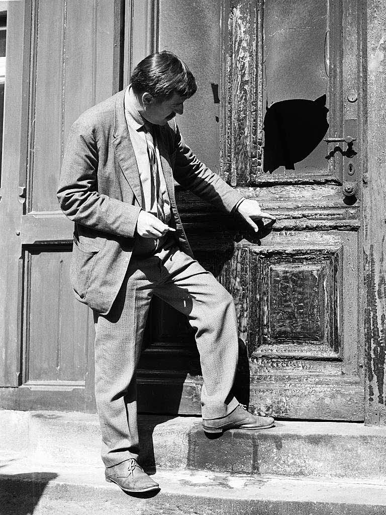 Der Schriftsteller Gnter Grass steht am 16.09.1965 vor der angekohlten Tr seines Hauses in Berlin-Friedenau.