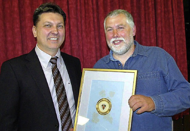 Frank Briem (links) ehrte im Namen des...hneider mit dem goldenen Gtezeichen.   | Foto: Herbert Trogus