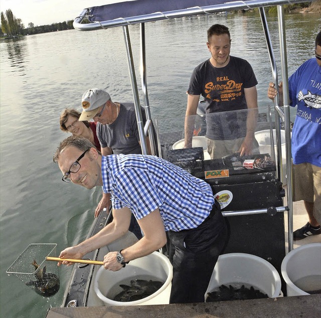Die Fische werden in den Rhein entlass...chef der DSM, Jrgen Wick (mit Netz).   | Foto: Heinz Vollmar