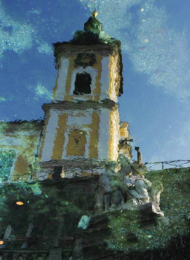 Der Kirchturm von St. Johann spiegelt ...ueschingen im Wasser der Donauquelle.   | Foto: dpa