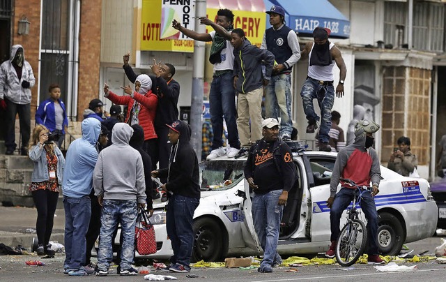 Schwarze Jugendliche in Baltimore auf einem zerstrten Polizeiauto   | Foto: AFP