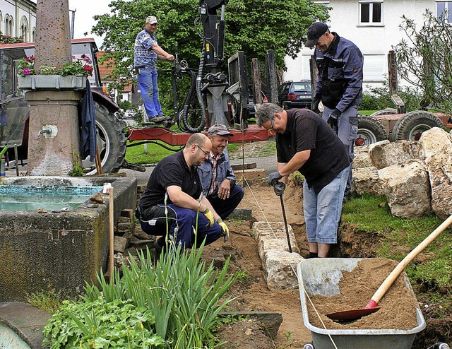 Krftig mit anpacken mussten die Helfe...mauer am Dorfbrunnen in der Ortsmitte.  | Foto: Reinhard Cremer