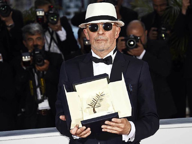 Regisseur Jacques Audiard mit seiner Trophe in Cannes: der Goldenen Palme  | Foto: AFP