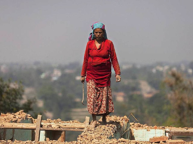 Eine Frau luft auf den Ruinen ihres z...  die Menschen wurden zu Flchtlingen.  | Foto: dpa