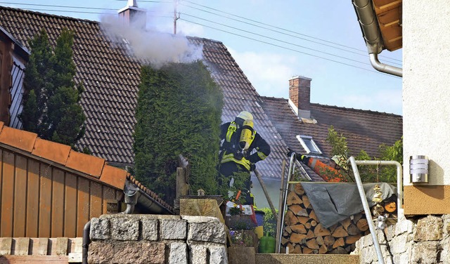 Einsatz im Garten: Zwei Feuerwehrmnne...n die Hecke, die in Brand geraten ist.  | Foto: Kamera 24