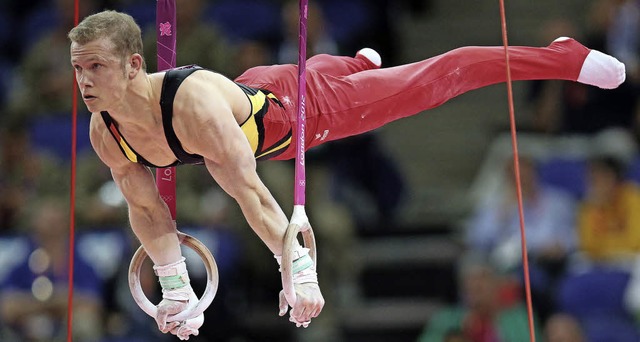 Kunstturner Fabian Hambchen, hier bei...trger bei der Erffnung am Freitag.    | Foto: dpa