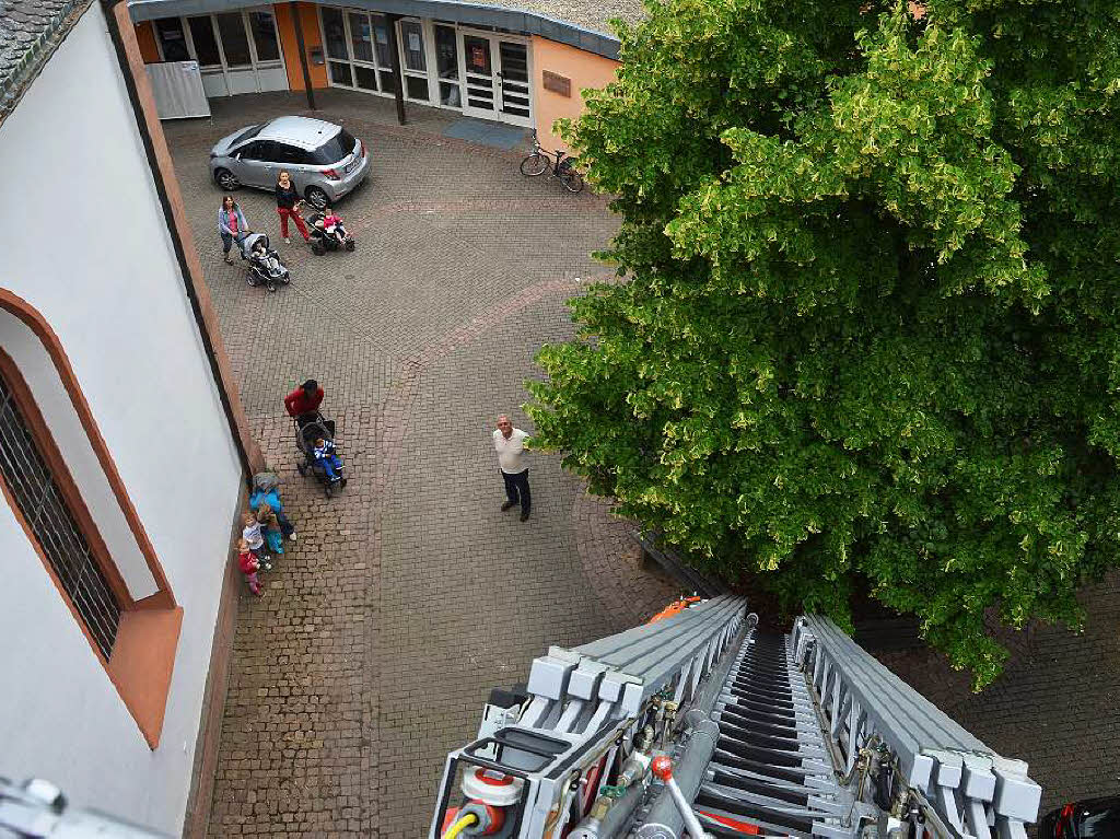 Martin Kury und Heinz Jund beringen den Jungstorch auf dem Dach der evangelischen Kirche in Denzlingen.