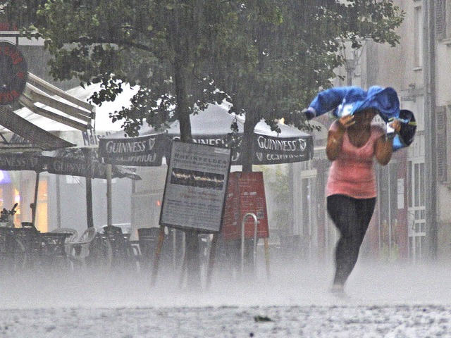 Rette sich wer kann. Eine Frau rennt m...opf gestlpten Jacke durch den Regen.   | Foto: Moritz Lehmann